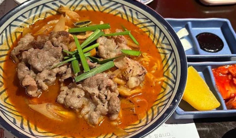 Spicy Korean noodles with meat topping at DOYA JJAMBBONG