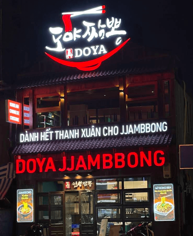 DOYA JJAMBBONG neon storefront at night in District 1 Ho Chi Minh City